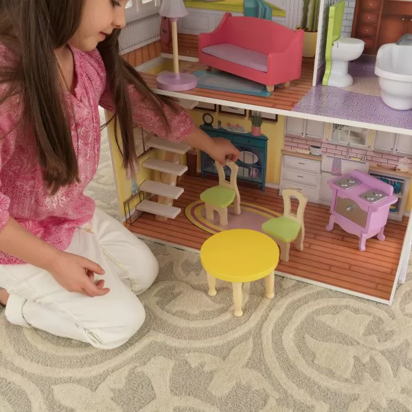 Detalle de niña jugando con sillas y mesa en la cocina de casa kidkraft de muñecas poppy 65959
