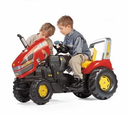 Detalle del capó abierto del tractor rolly x-trac luxe con niños jugando con él
